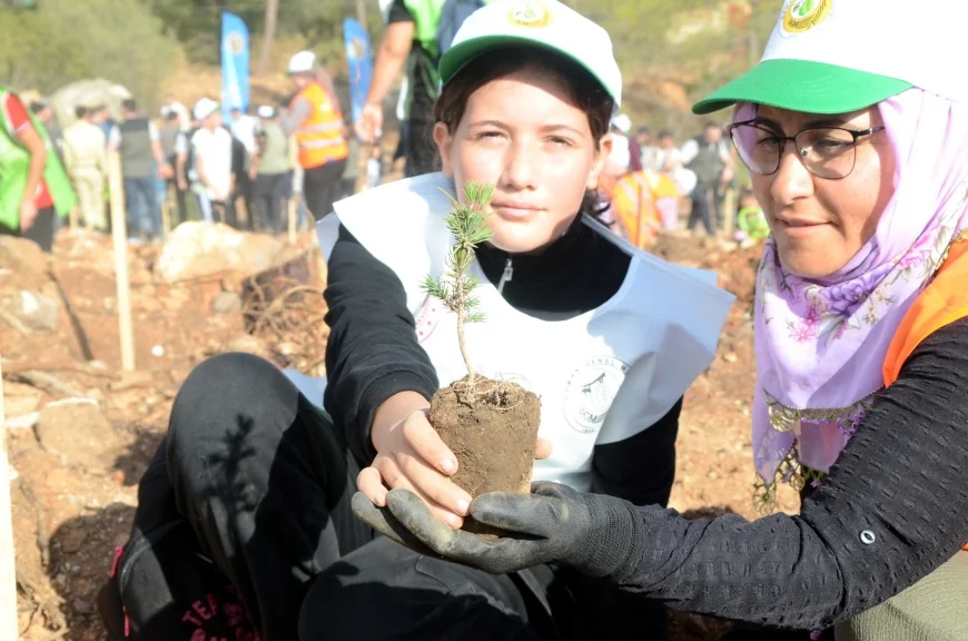 Bodrum’da yanan alanlarda  yüzlerce fidan toprakla buluştu, 10 aylık Kerem bebek ilk fidanını dikti