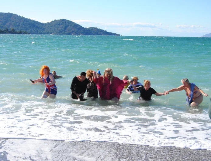 Çocuklara yardım amacıyla kostümlerle buz gibi havada denize girdiler